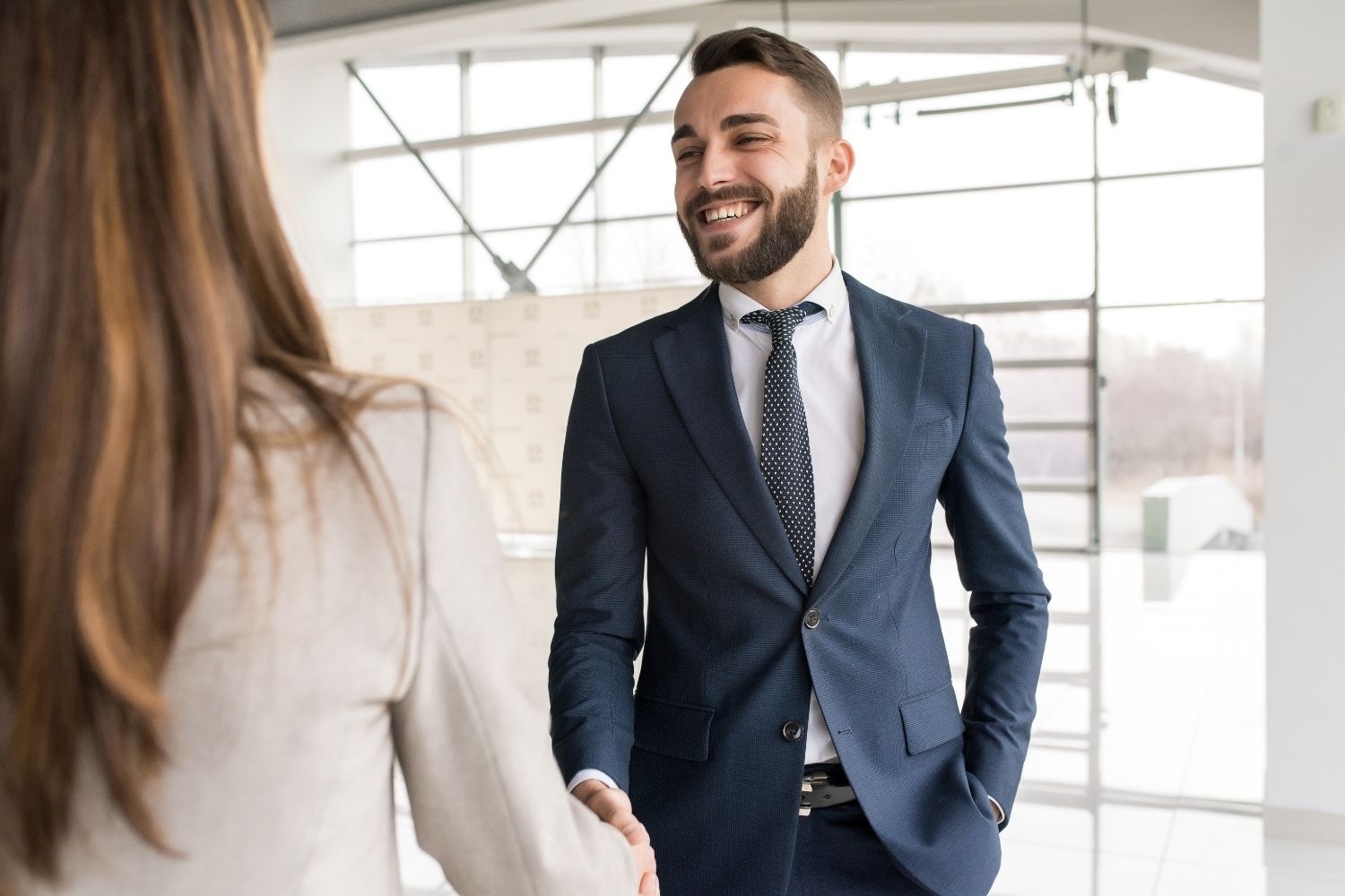 uomo che stringe la mano a una donna per festeggiare la chiusura di un contratto di lavoro